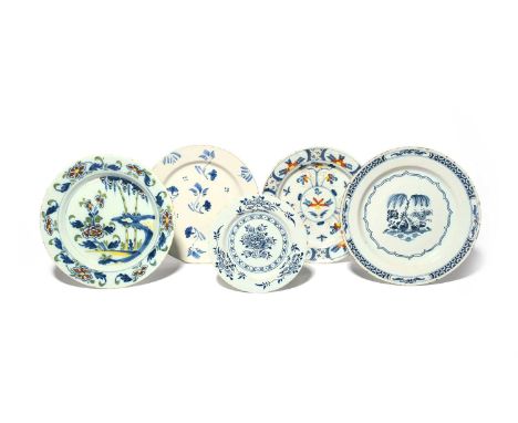 Five delftware plates, c.1740-60, one painted with bamboo and peony, another with a formal floral design, one of primitive sh