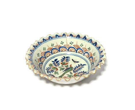 A Bristol delftware wig bowl, c.1720, painted in blue, red and green with a bird perched on a leafy branch, the cavetto with 