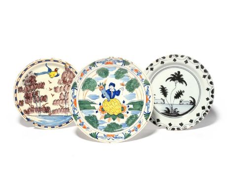 A Brislington delftware plate, c.1720, painted in blue, red and yellow with a bird in flight above sponged manganese trees, a