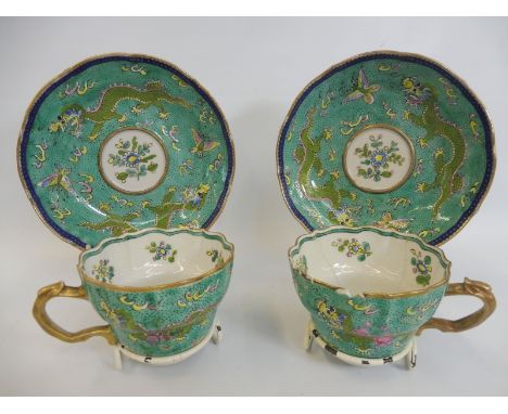 A pair of Chinese cups and saucers of colourful design.