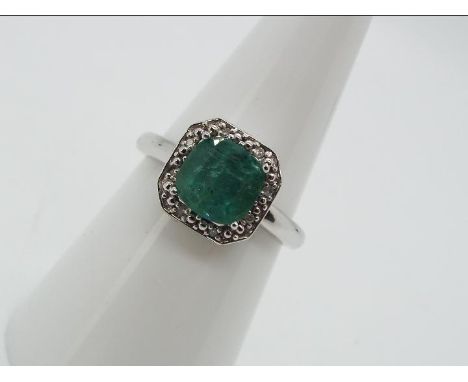 9ct Gold - a 9ct white gold ring set with diamonds and emerald, brilliant shape,size N, weight 0.04 carats, clarity SI, colou