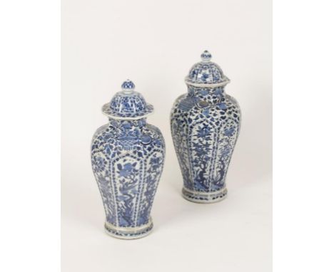 A PAIR OF CHINESE OCTAGONAL PANELLED BLUE AND WHITE VASES each panel painted with a different flowering shrub inhabited by bi