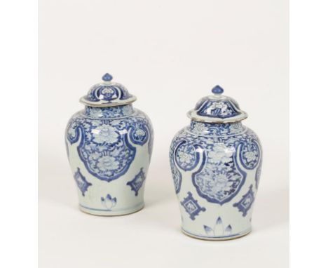 A PAIR OF CHINESE BLUE AND WHITE PORCELAIN VASES AND COVERS painted with large repeating ruyi-head lappets enclosing richly b