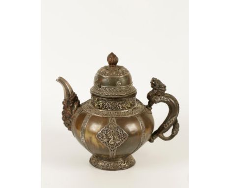 A TIBETAN WHITE METAL AND PARCEL GILT MOUNTED TEAPOT, finely worked around the globular body with apsaras, birds and foliate 