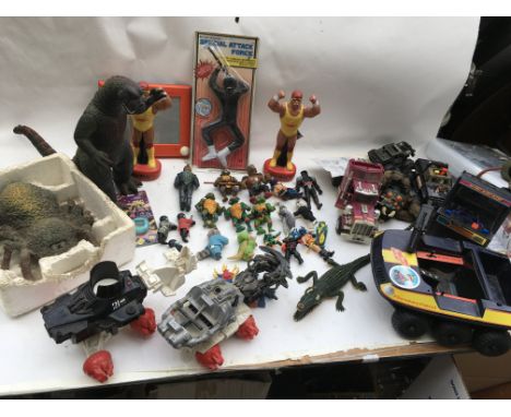 A box containing a collection of loose random toys including Godzilla figure, Teenage Ninja turtle figures, Mask Rhino truck,