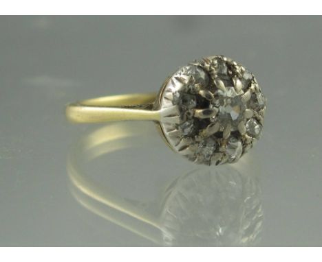 A DIAMOND CLUSTER RING. The nine old cut diamonds set in silver on an 18ct gold band. Ring size R 1/2. Weight 4.2g approx. (B