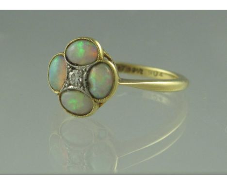 AN OPAL AND DIAMOND RING. Set with four well matched opals with an old cut diamond to the centre. Ring size L. Weight 2.5g ap