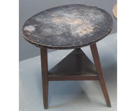 19TH CENTURY TRADITIONAL WELSH OAK AND PINE CIRCULAR CRICKET TABLE with triangular legs and under shelf. 70cm diameter by 78c