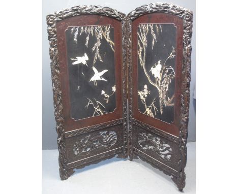 EARLY 20TH CENTURY JAPANESE CARVED LACQUERED AND STAINED HARDWOOD TWO FOLD SCREEN decorated overall with inset mother of pear