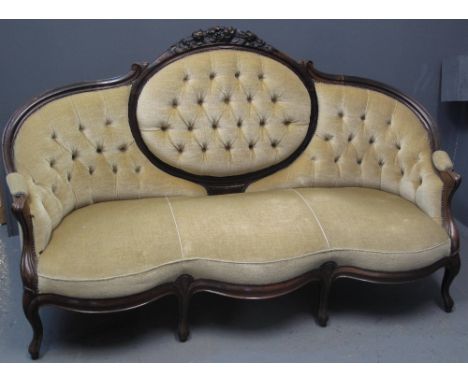 VICTORIAN ROSEWOOD THREE SEATER SOFA having carved flower head and foliage decoration, the back with button back upholstery, 