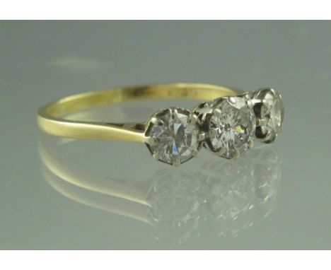 A THREE STONE DIAMOND RING. The brilliant cut diamonds an estimated total weight of 1.1cts. Ring size R 1/2. Weight 2.9g appr