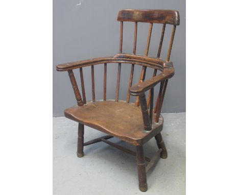 19TH CENTURY ELM AND BEECH STICK BACK FIRESIDE ELBOW CHAIR with curved top rail, moulded saddle seat on a turned under frame.