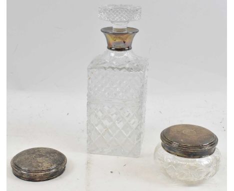 A cut glass decanter with silver collar, height 24cm, also a jar with silver top and a further silver top, combined 2.73ozt/8