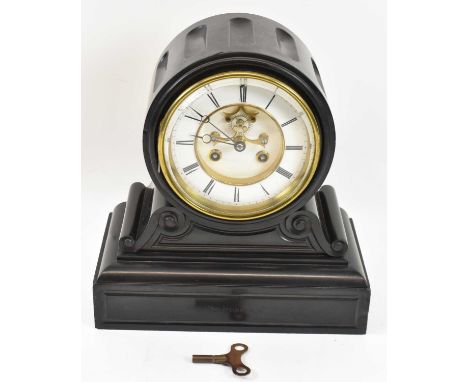 A late Victorian black slate eight day mantel clock with white enamel dial and visible escapement, height 29cm.