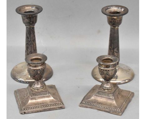 Two pairs of hallmarked silver candlesticks, Birmingham 1910 and 1911, height 12.5cm and 7.5cm respectively, both loaded.