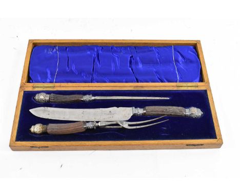 A late Victorian oak cased three piece carving set with antler handles and silver mounts.