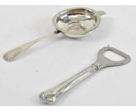 A Danish silver tea strainer and a silver handled bottle opener (2).