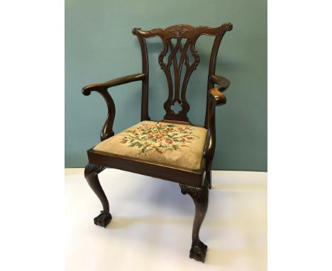 A Georgian Chippendale arm chair, Supported on ball & claw feet. Seat base is done with tapestry depicting flowers & foliage.