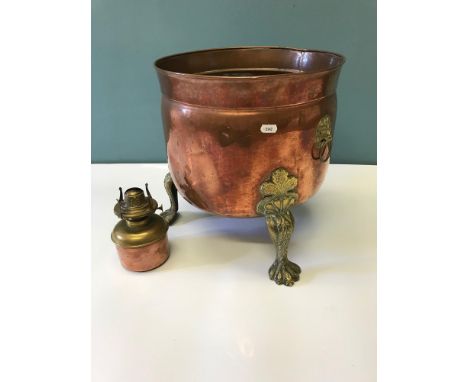Large arts and crafts copper and brass three foot planter. Styled with lion head handles, ornate brass claw feet supports. To