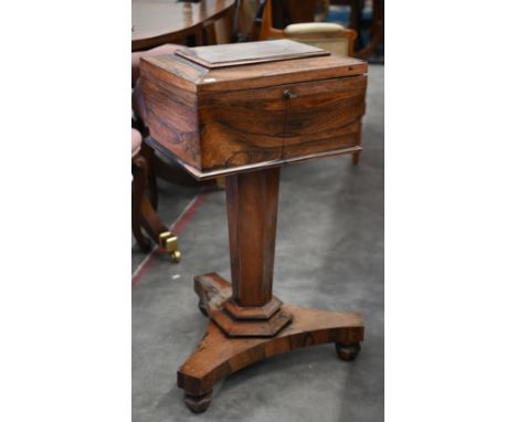 A Victorian rosewood teapoy of sarcophagus form raised on a tapering support to a platform base on shaped feet and concealed 
