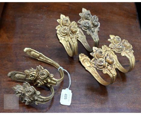 A set of three pairs of gilt brass curtain tie-backs 