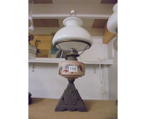 An old oil lamp on cast metal base and with hand painted font. COLLECT ONLY.