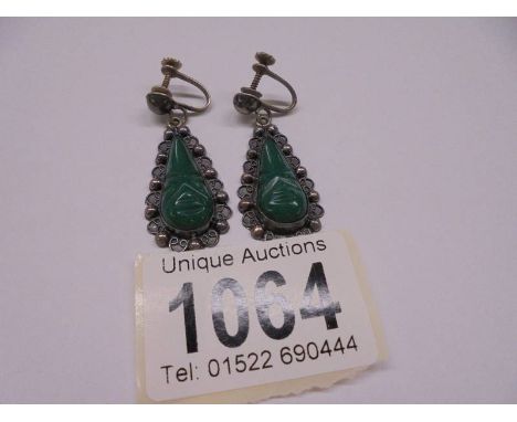 A pair of silver and jade pendant earrings.