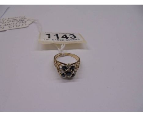 A 9ct gold diamond and sapphire ring with textured shoulders, dated London 1975, size M half, 4 grams.
