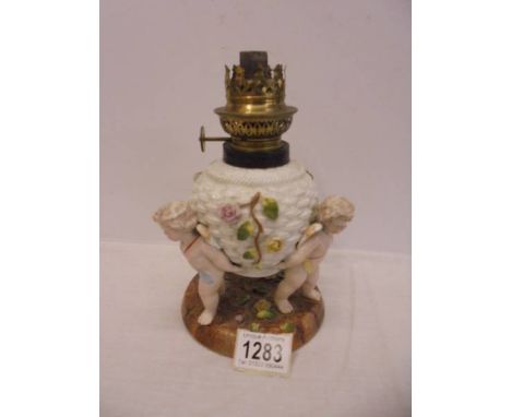 A Victorian cherub oil lamp with crossed swords makers mark.