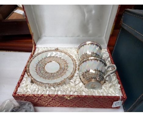 A cased pair of porcelain tea cups &amp; saucers from Thailand