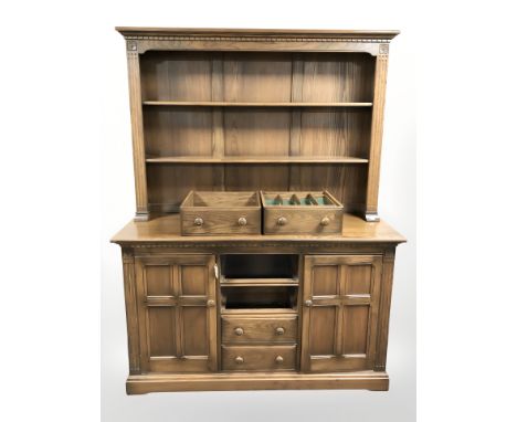 An Ercol elm dresser, 145 cm x 53 cm x 190 cm. CONDITION REPORT: Two central drawers do not fit and will require planing.