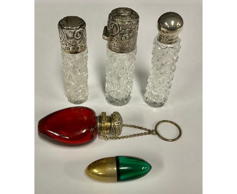 A Victorian silver mounted scent bottle, the hinged cover chased with foliate scrolls, enclosing a glass stopper, 8cm high, B
