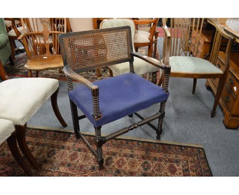 A mahogany armchair with canework back, over-stuffed seat and bobbin turned stretchers and legs.