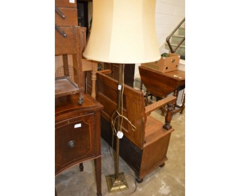 A brass standard lamp and a sewing trolley.
