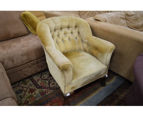 A button upholstered tub shaped armchair on cabriole legs.