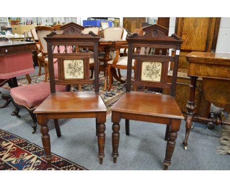 A pair of Victorian mahogany hall chairs with tile inset back panel.