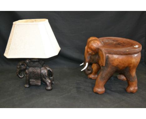 A tribal hardwood table, carved as an elephant, flattened plateau top, 20th century; a bronzed composition table lamp, as an 
