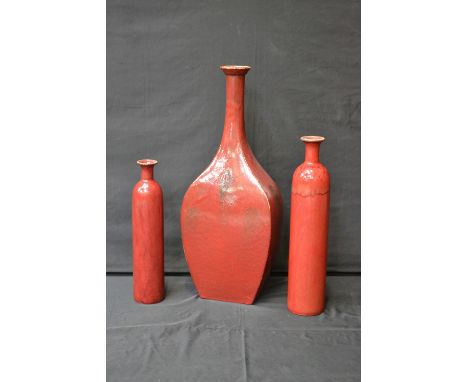 A set of three ceramic floor standing vases, drip glazed in sang-de-boeuf tones, the largest 77.5cm high