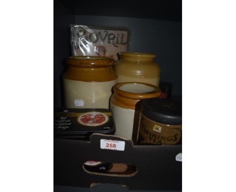 Three salt glazed jars, three vintage Twinings Tea tins and a reproduction Bovril advertising sign.