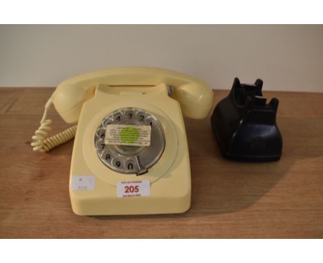 A retro beige plug in telephone having a rotary dial and coiled cable, w19cm.
