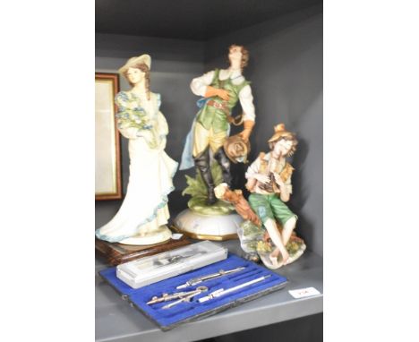 A Capodimonte figurine by Tosca of a young man, a similar Capodimonte study of a pipe player AF and a vintage travelling cart
