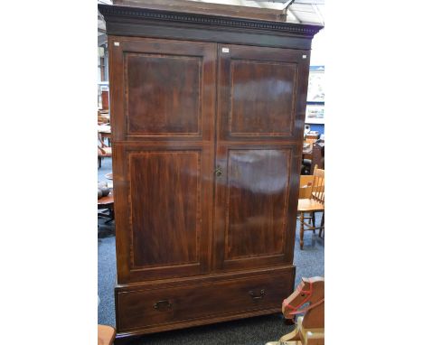 An Edwardian mahogany wardrobe, dentil cornice above a pair of panel doors enclosing a hanging rail and an arrangement of hoo