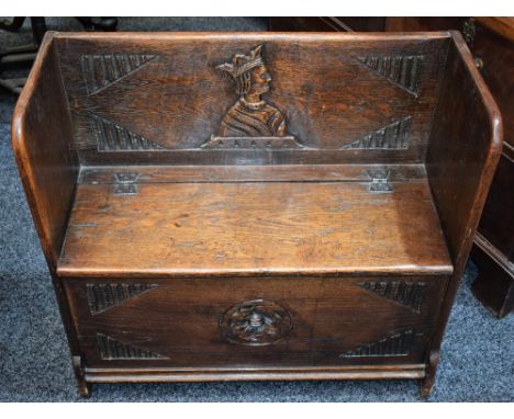 An oak hall settle, carved with a portrait roundel and rose, mid-20th century