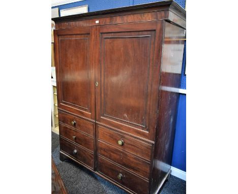 A 'George III' mahogany wardrobe, disguised as a linen press, outswept cornice above a pair of doors, enclosing a hanging rai