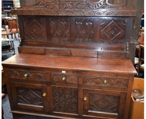 A 17th century style oak sideboard, rectangular top with half gallery housing plate rack and small drawers, above three short