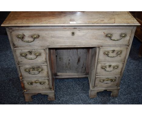 A George III mahogany kneehole desk, crossbanded moulded top above a frieze drawer, cupboard to niche, flanked by two rows of