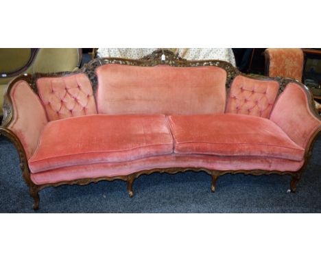 A substantial Rococo Revival sofa, shaped partial-button back pierced and carved throughout with C-scrolls, bell husks, flowe