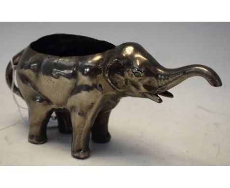 An Art Deco silvered metal pin cushion, as a standing Elephant, trunk raised, black cloth, cushion back, 19cm long