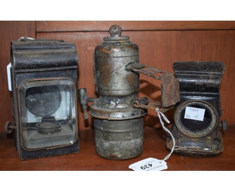 An acetylene lamp; another, similar; a hand oil lantern (3)