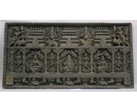 A MONUMENTAL DEEPLY CARVED WOODEN PANEL, depicting various Hindu gods seated on a lotus wearing jewellery and crown, the temp